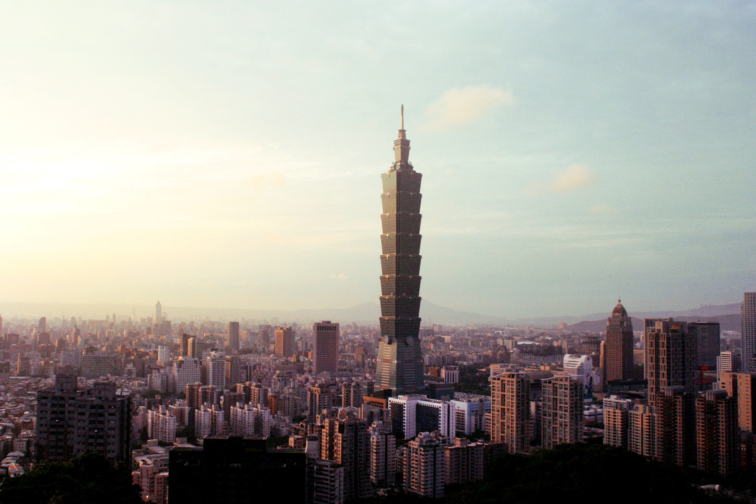 Taipei 101 tower rising above the city skyline at dusk